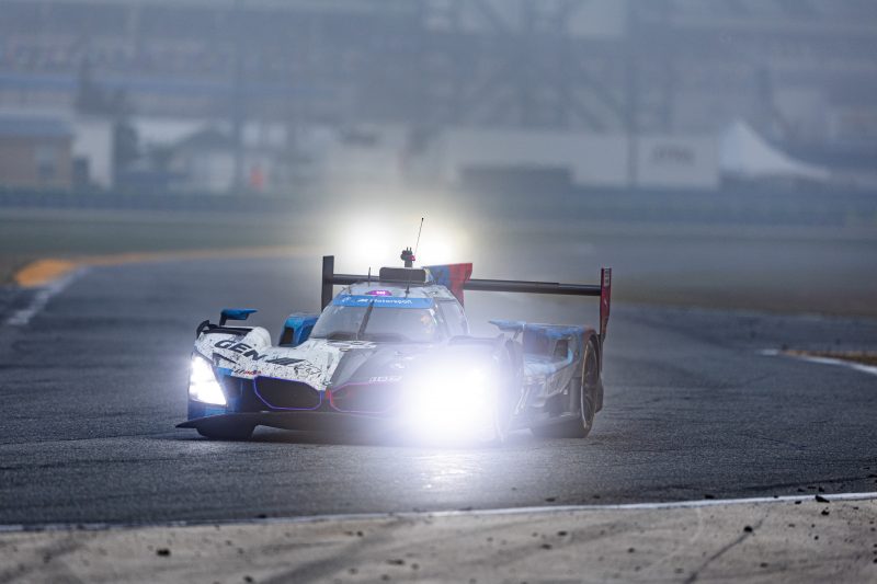 A battle-scarred #24 BMW negotiates a turn in the early hours of the 2026 Rolex 24 at Daytona